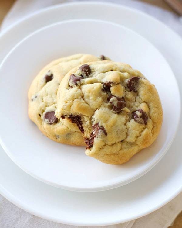 Two chocolate chip cookies on a white plate.