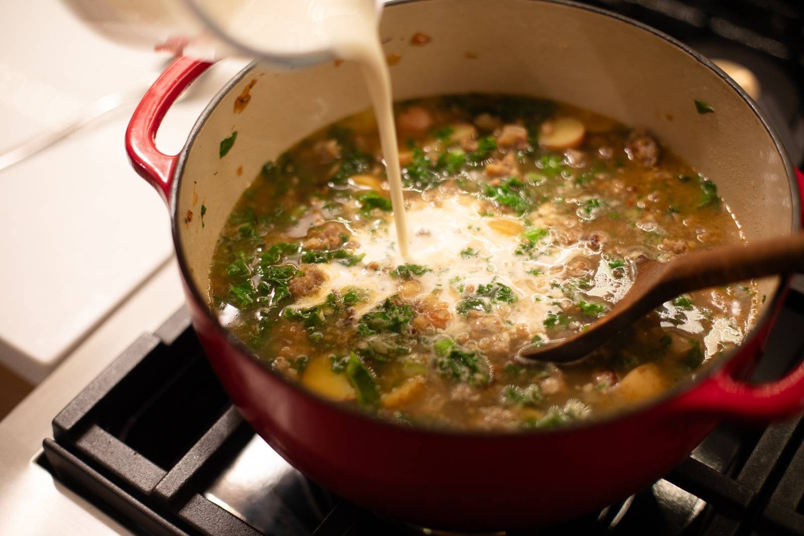 Adding cream and kale to the pot.