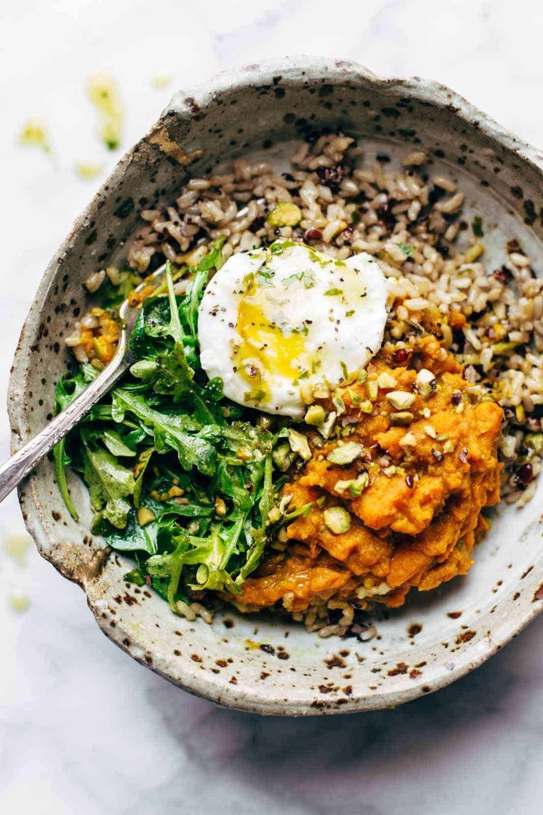Bowl with rice, sweet potatoes, greens, and a poached egg.