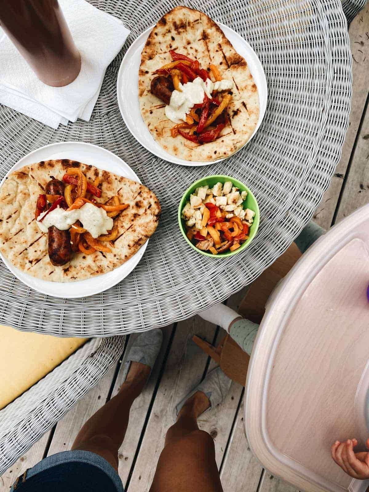 A plate of naan with sausage and peppers.