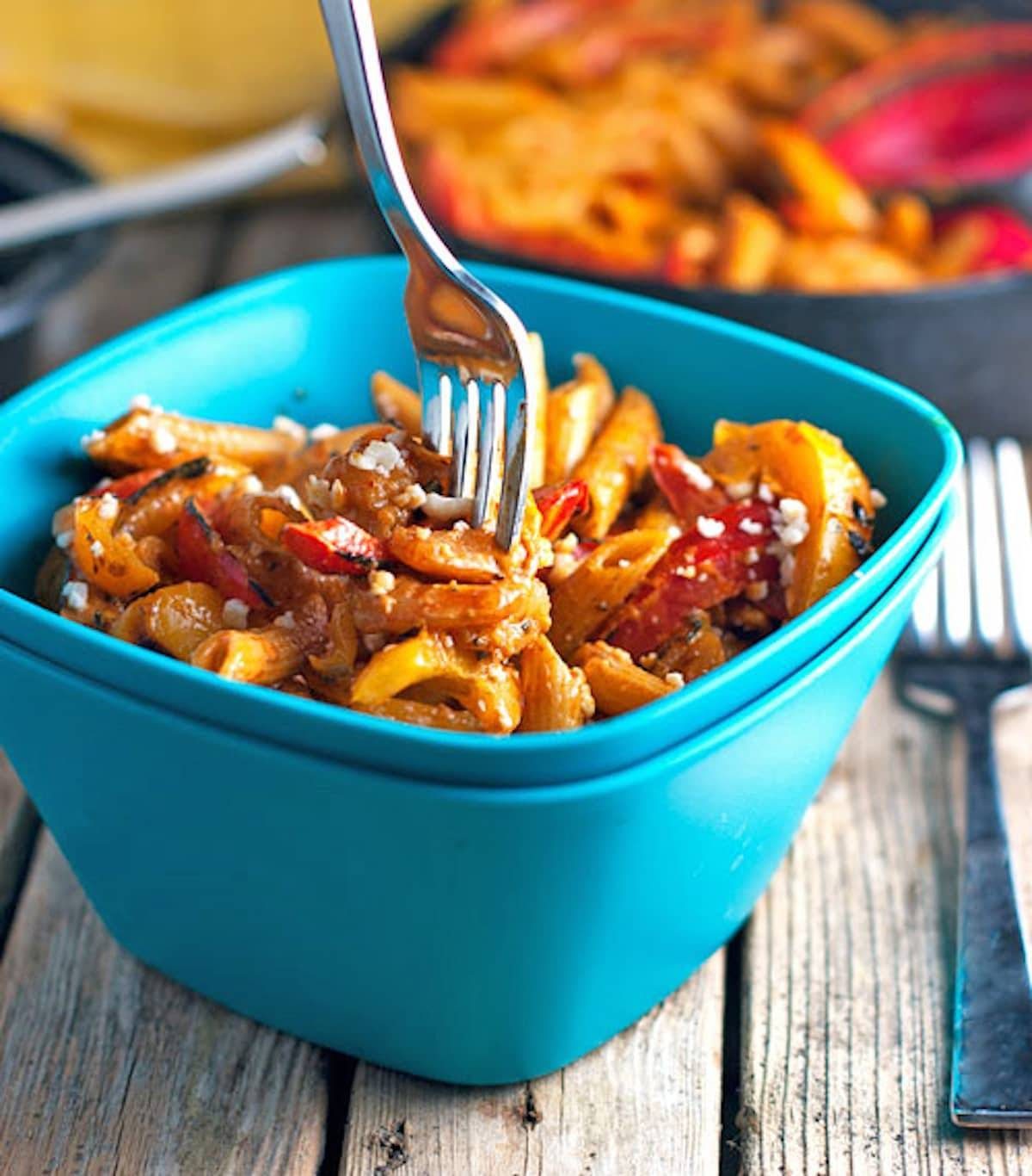 Skinny shrimp fajita pasta in a blue bowl with a fork.