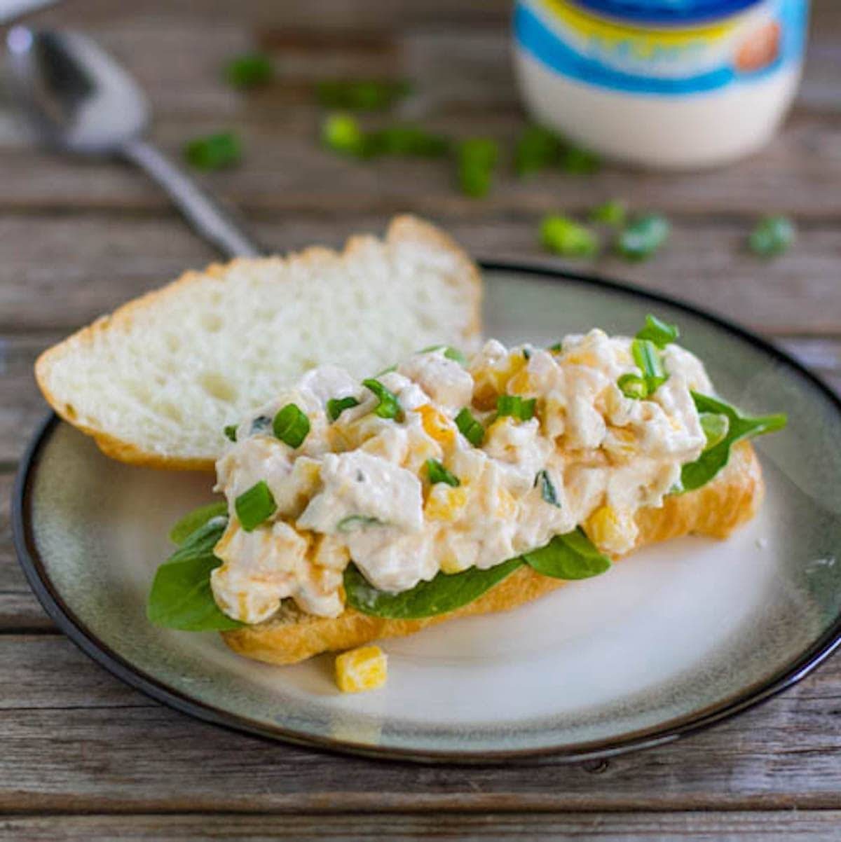 Mango chicken salad sandwich on a late.